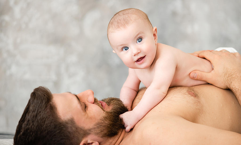 Vader en baby in buikligging positie