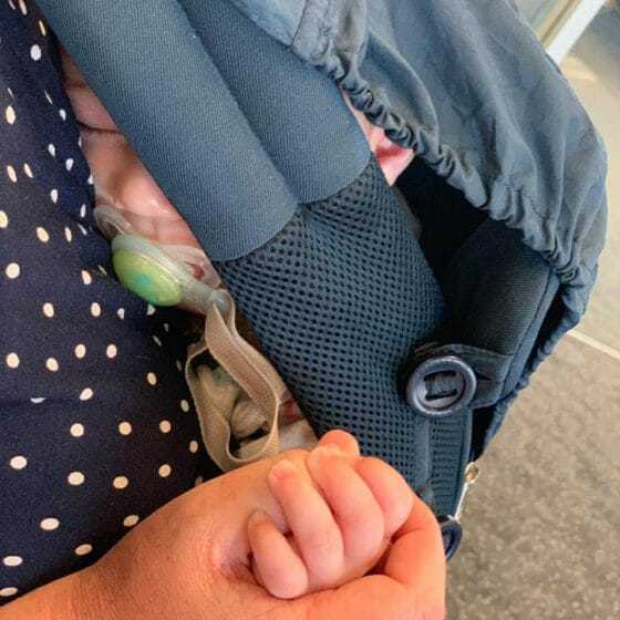 baby in draagzak op vliegtuig