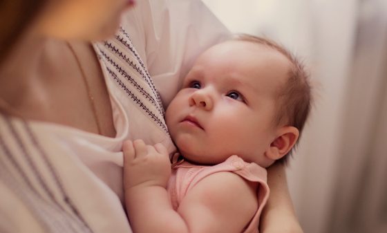 Baby laying with mother in arms