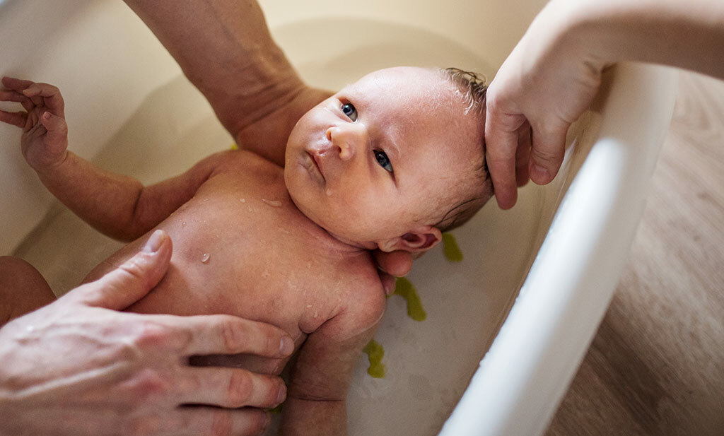 Pasgeboren baby neemt een bad