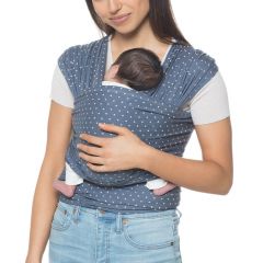 Mama draagt de baby op de buik met gezicht naar haar toe in Aura Wrap Coral Dots draagzak