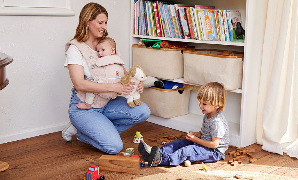 Moeder doet de lenteschoonmaak met baby in draagzak.