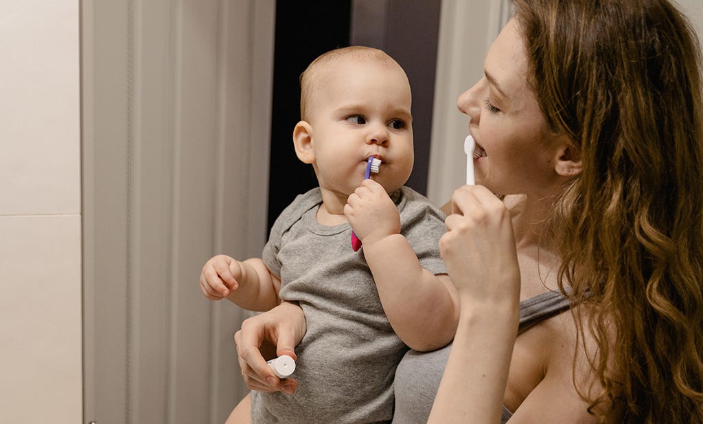 Mama en baby die tanden poetsen