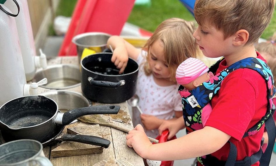 Kleuters spelen met de popendragen en doen aan rollenspel.<br />
